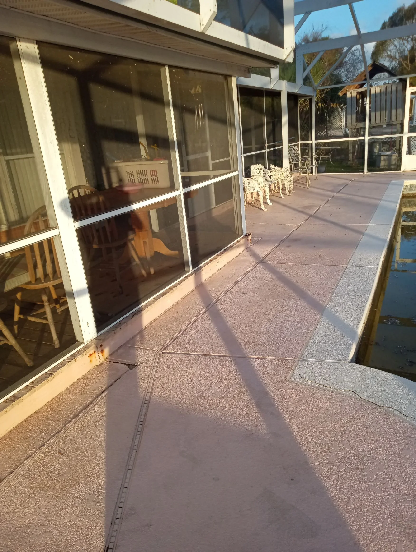 White aluminum screen porch with bronze screening, sliding doors, and concrete patio