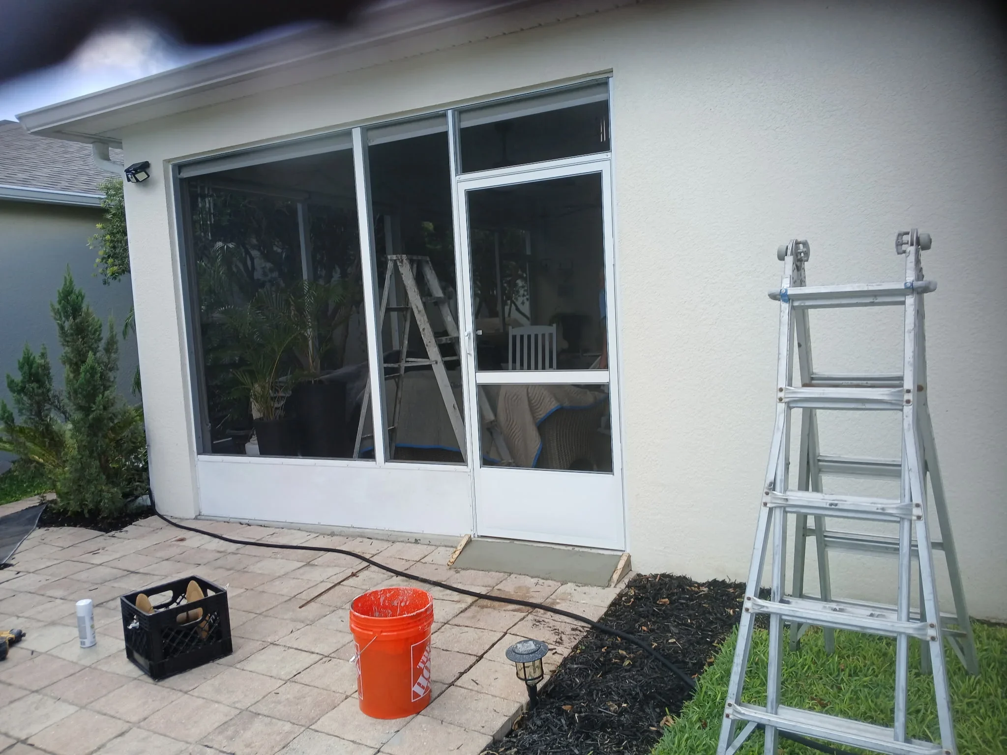 Aluminum sliding glass doors and windows installed on residential patio with white trim