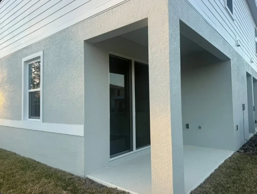Modern porch enclosure with stucco columns and concrete pad in Deltona