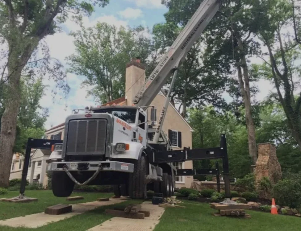 Crane truck removing large tree from residential yard in Deltona